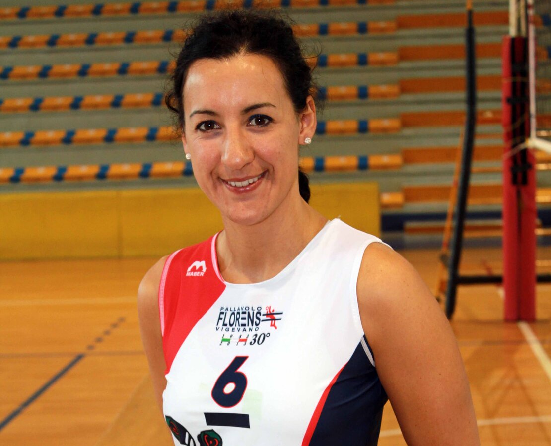 Giocatrici di pallavolo sorridenti abbracciate al centro del campo